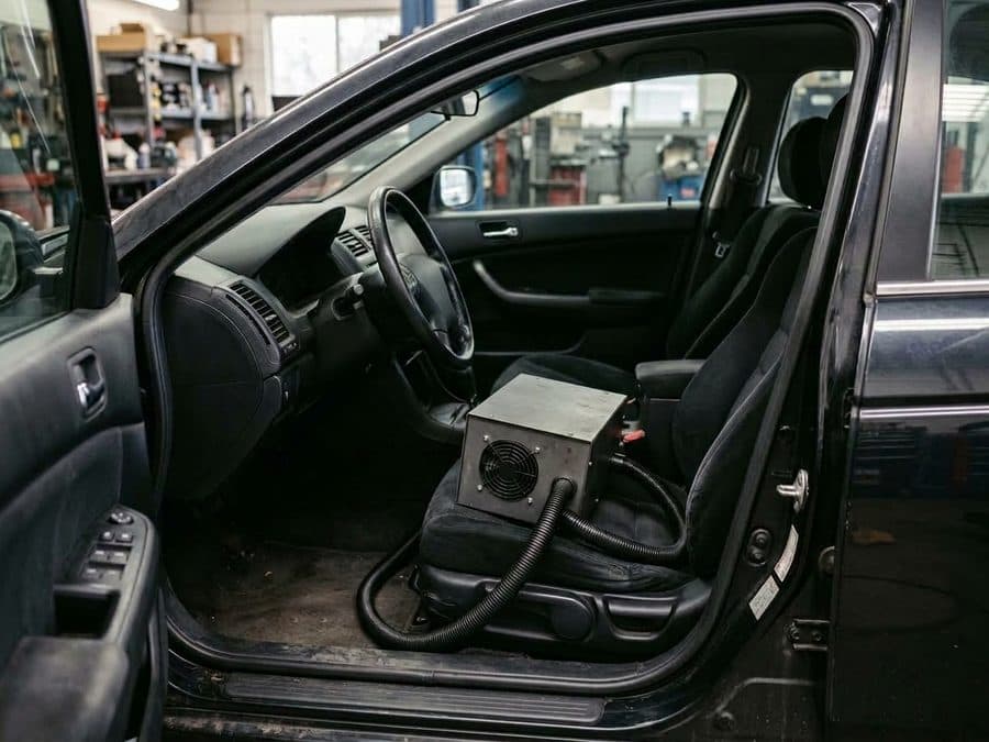 Ozongerät steht auf dem Fahrersitz eines Fahrzeugs mit geöffneter Tür