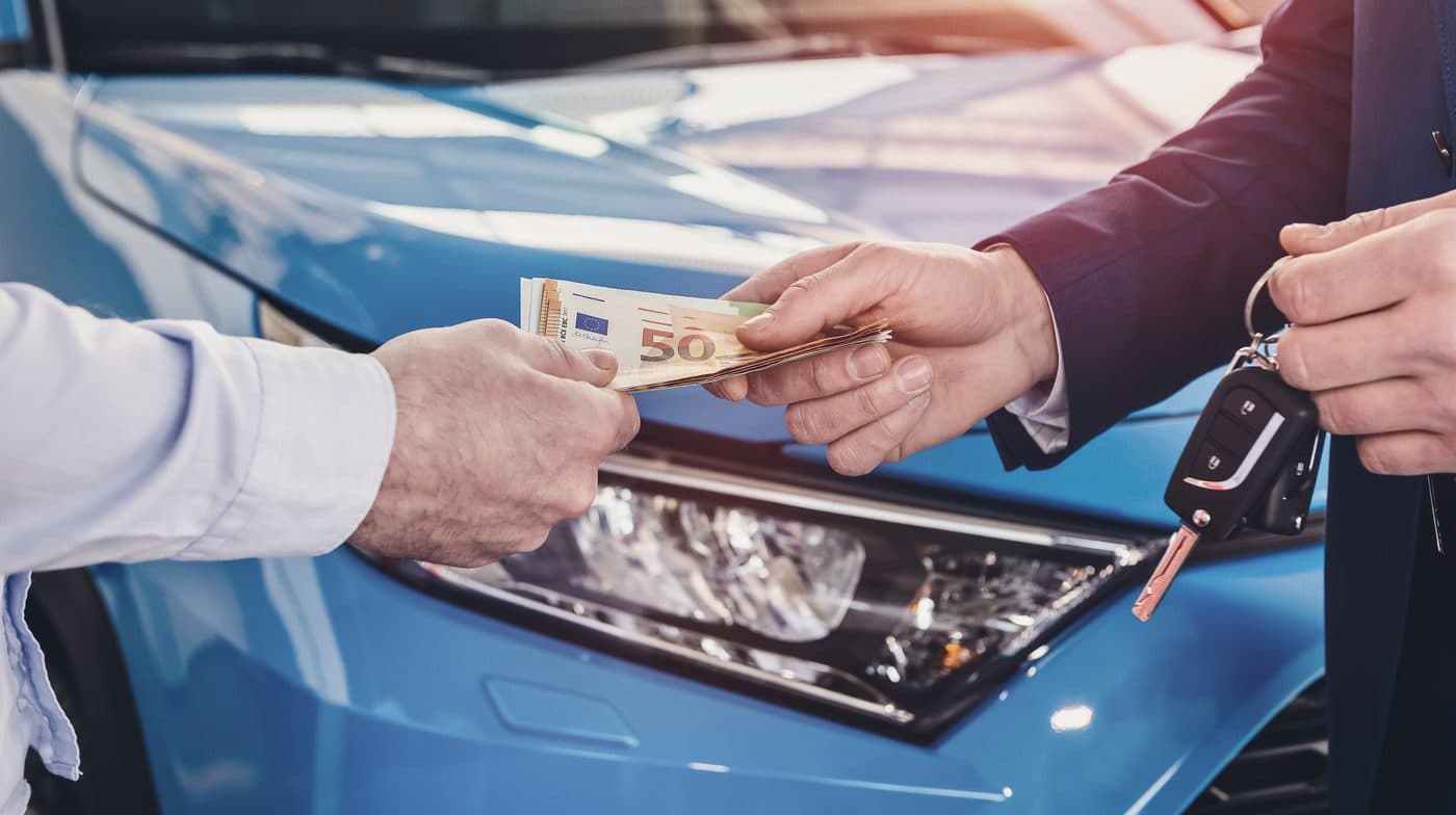 Fahrzeugverkauf: Geld und Autoschlüssel wechseln den Besitzer